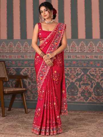 Woman in a vibrant red  saree with intricate floral embroidery and polka dot pattern.
