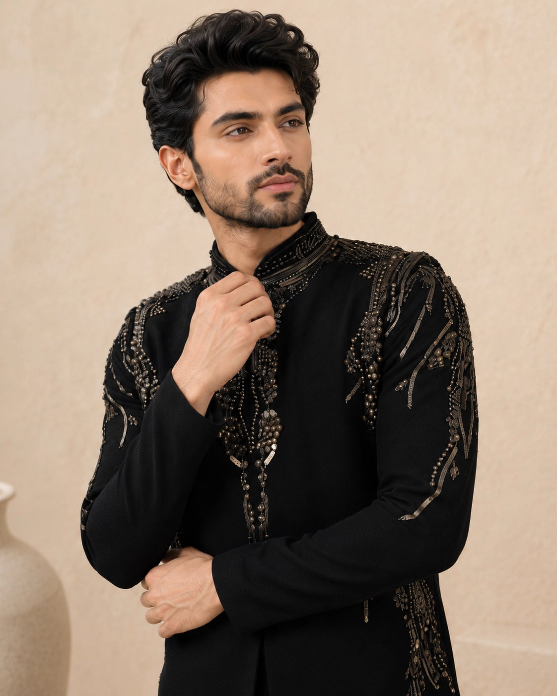 Man wearing a stylish black Indo-Western suit, showcasing intricate details and a modern fit.