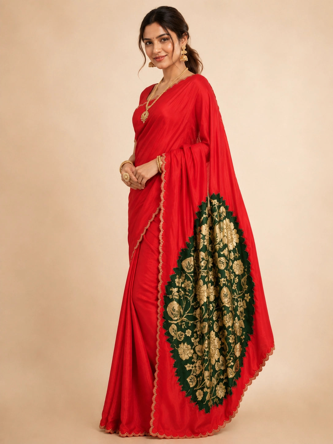 Woman wearing a vibrant red saree with a gold scalloped border and traditional jewelry.