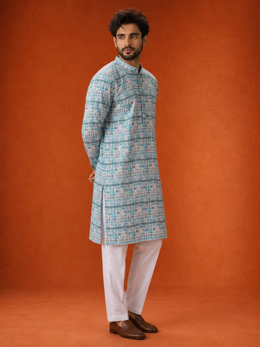 Man wearing an aqua and white printed kurta with white pajamas and brown loafers.