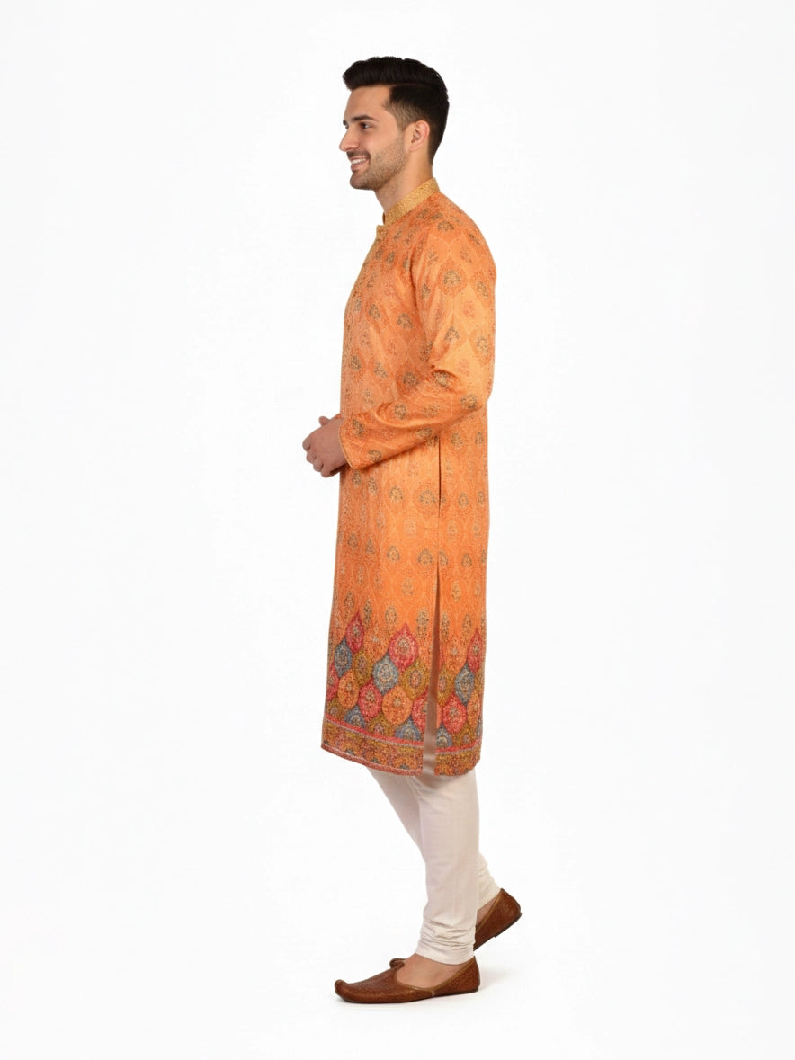 Man wearing an orange embroidered Kurta Pajama with cream pants and brown shoes, showcasing intricate patterns.
