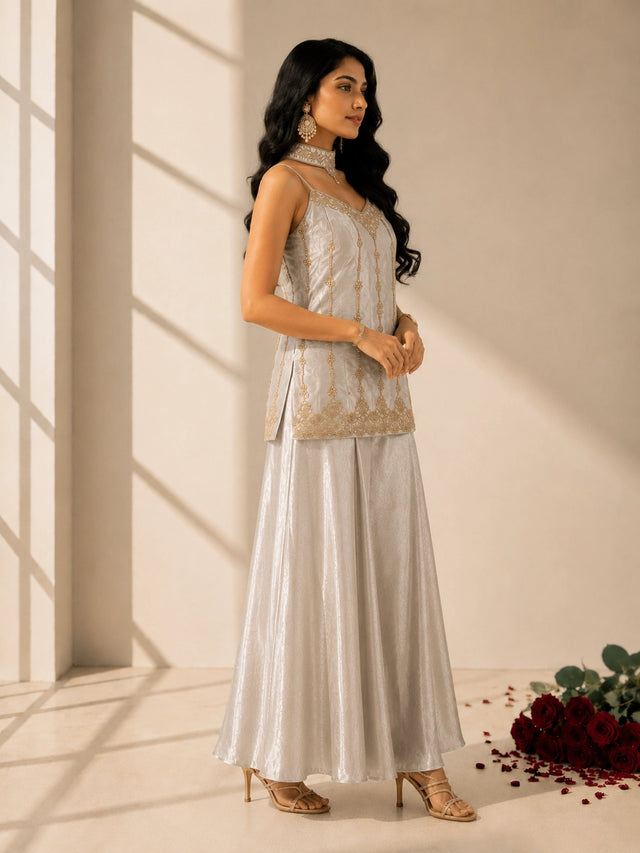 Woman in elegant grey sleeveless kurti with gold embroidery and matching palazzo pants.