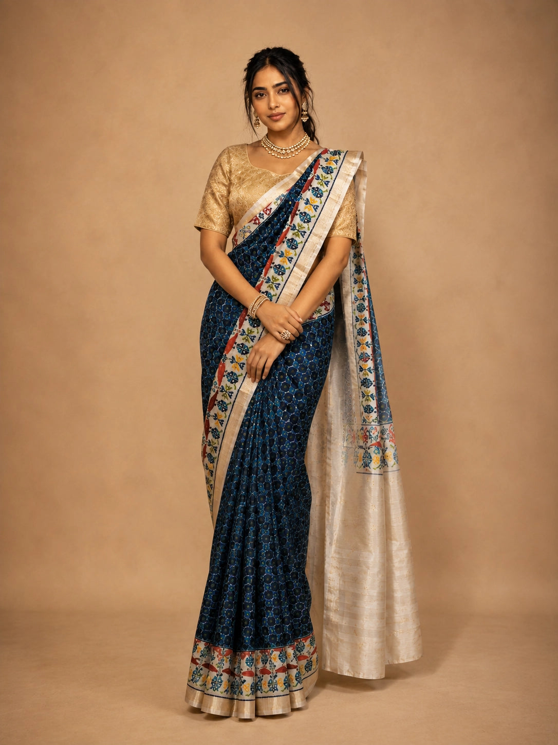 Woman in elegant navy blue  ikat saree with golden blouse and traditional jewelry.