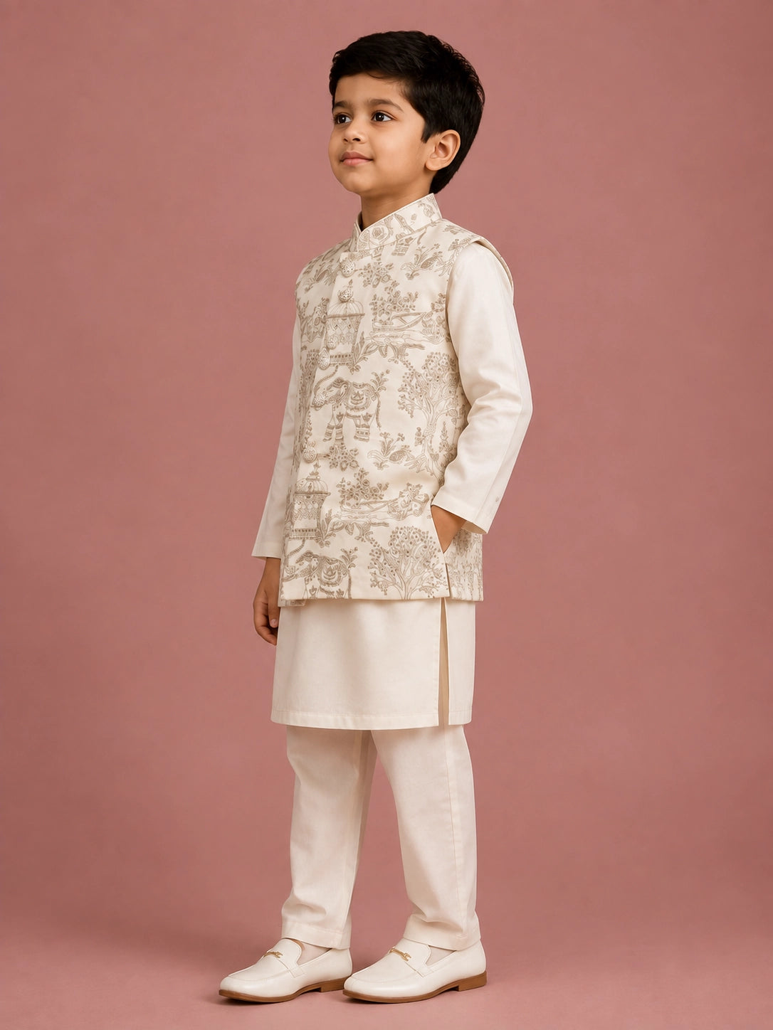Young boy wearing an off-white embroidered bandhgala waistcoat over a kurta pajama.