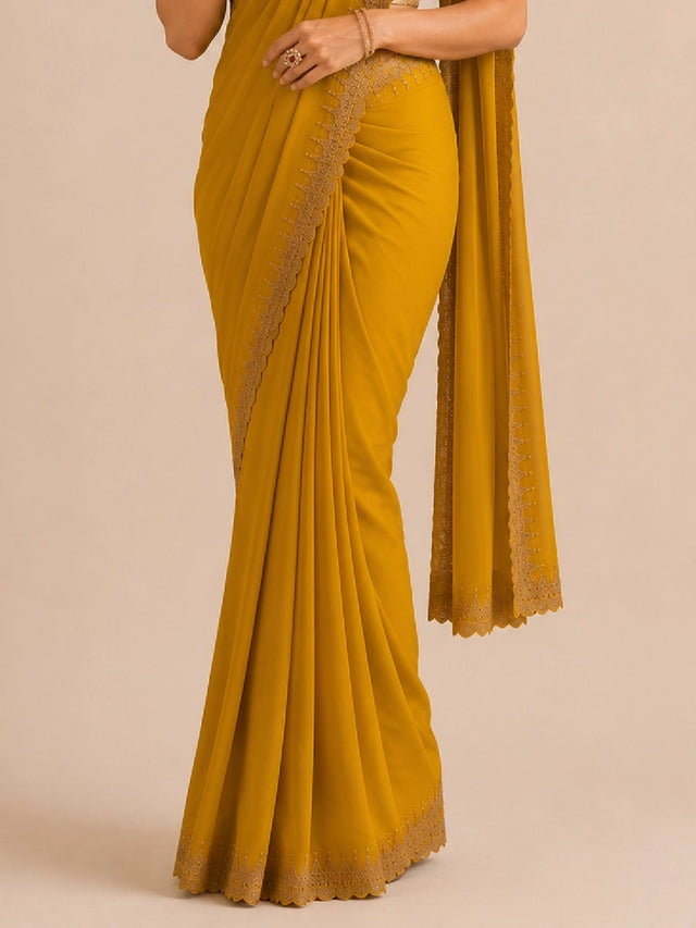 Woman in elegant mustard  saree with delicate embroidered border and golden blouse.