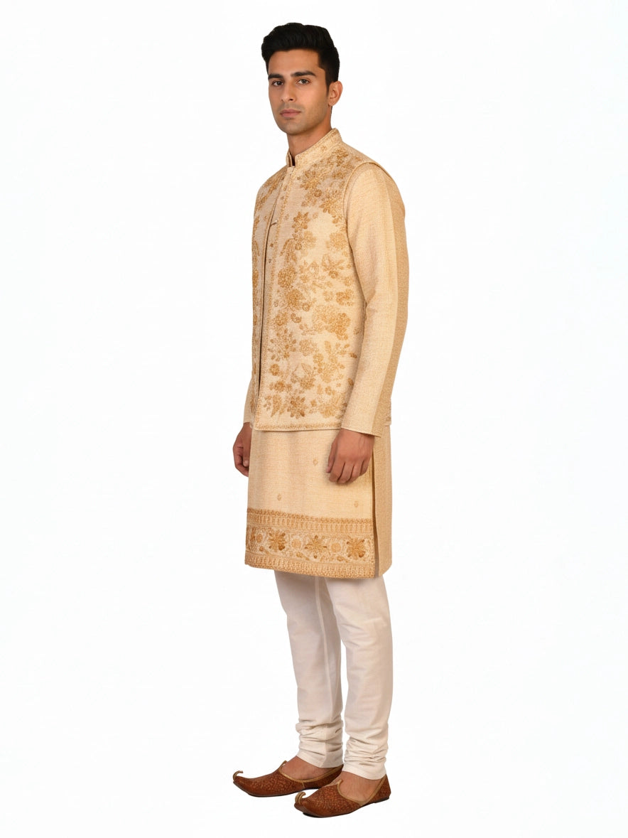 Man wearing a beige embroidered kurta jacket set with golden floral patterns, suitable for festive occasions.