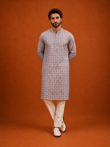 Man wearing a slaty patterned kurta with a mandarin collar, paired with cream pajama.