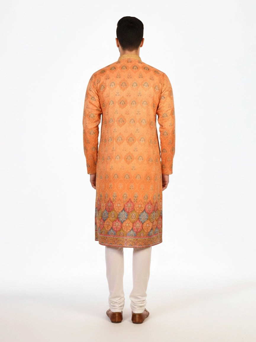 Man wearing an orange embroidered Kurta Pajama with cream pants and brown shoes, showcasing intricate patterns.