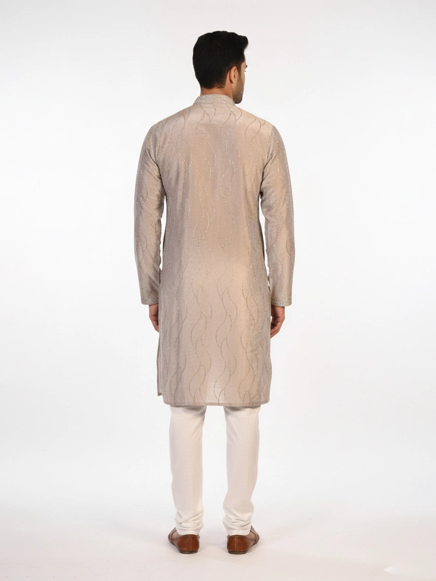 Man wearing a multi-color textured kurta with shimmering accents and cream pants, ready for festive occasions.