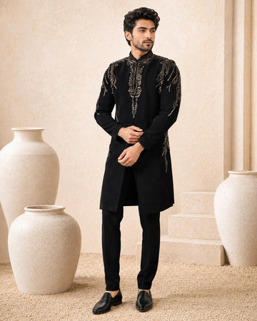 Man wearing a stylish black Indo-Western suit, showcasing intricate details and a modern fit.