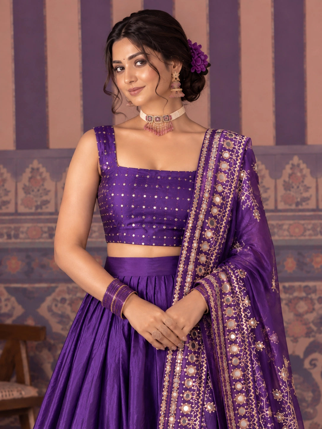 Woman in a vibrant purple embroidered lehenga choli set with gold patterns.