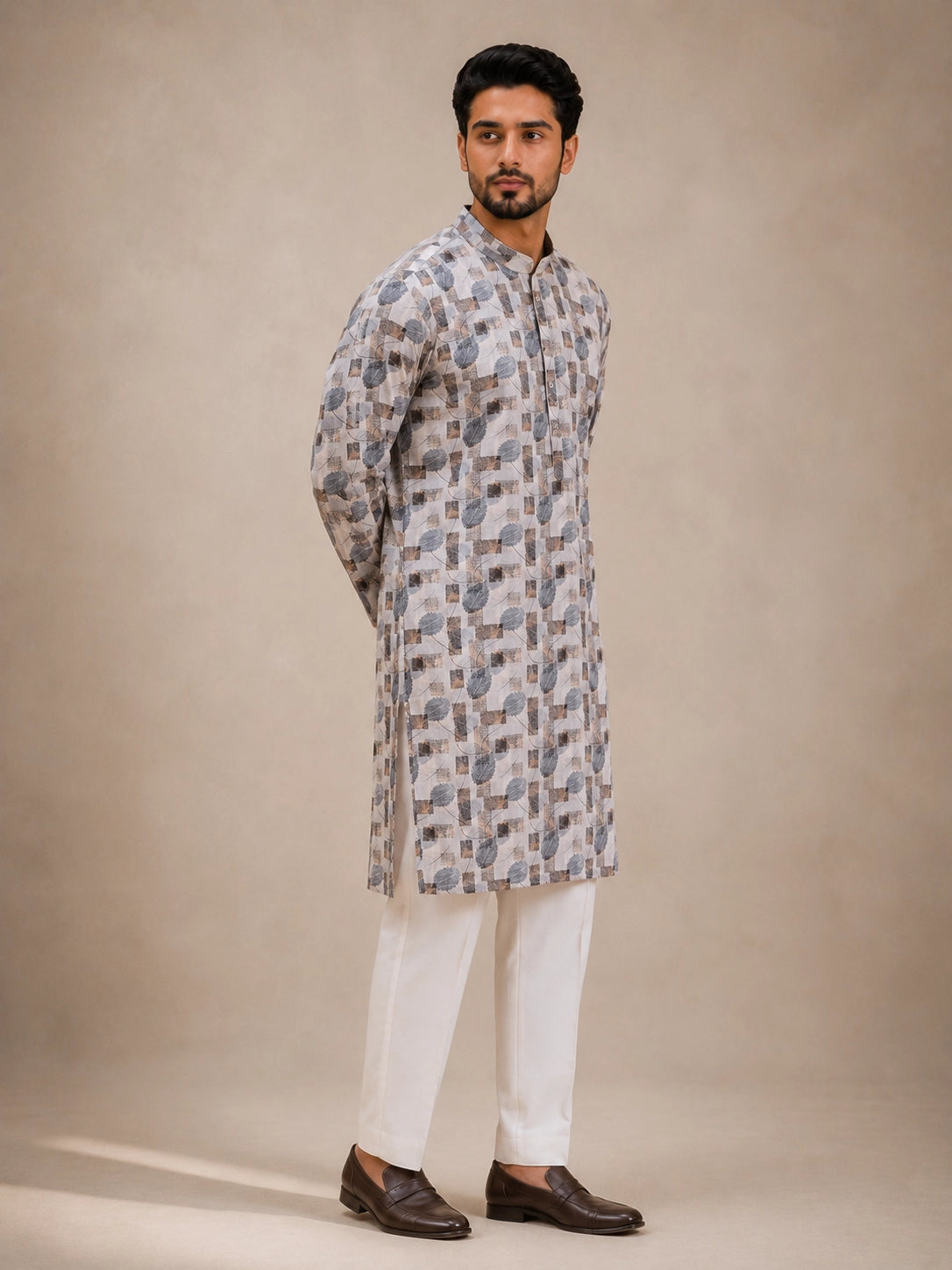 Man wearing an ice grey printed kurta with white pajama and brown loafers.