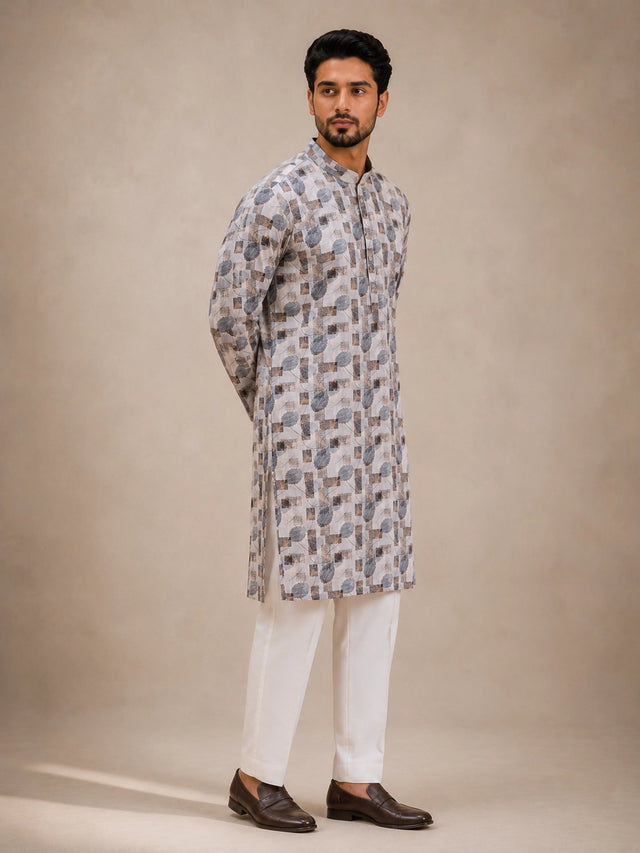 Man wearing an ice grey printed kurta with white pajama and brown loafers.
