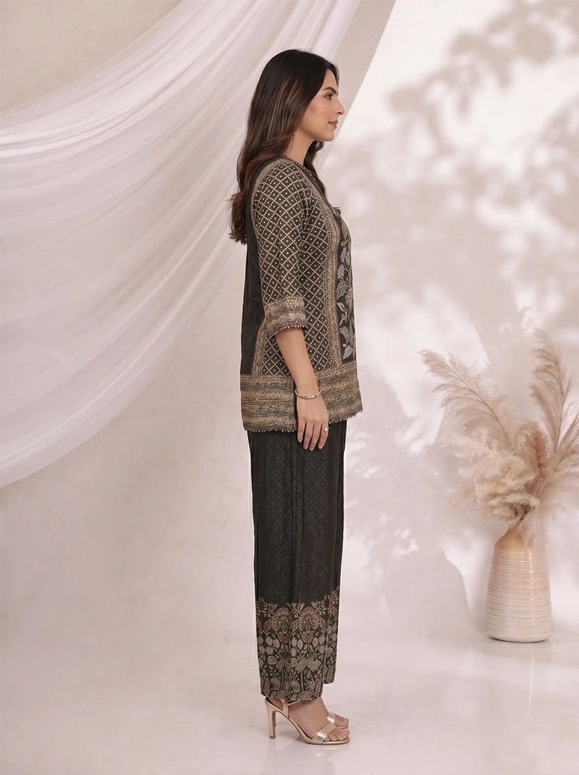 Woman wearing a black printed kurta with wide-leg pants, featuring floral motifs and a contrasting border.