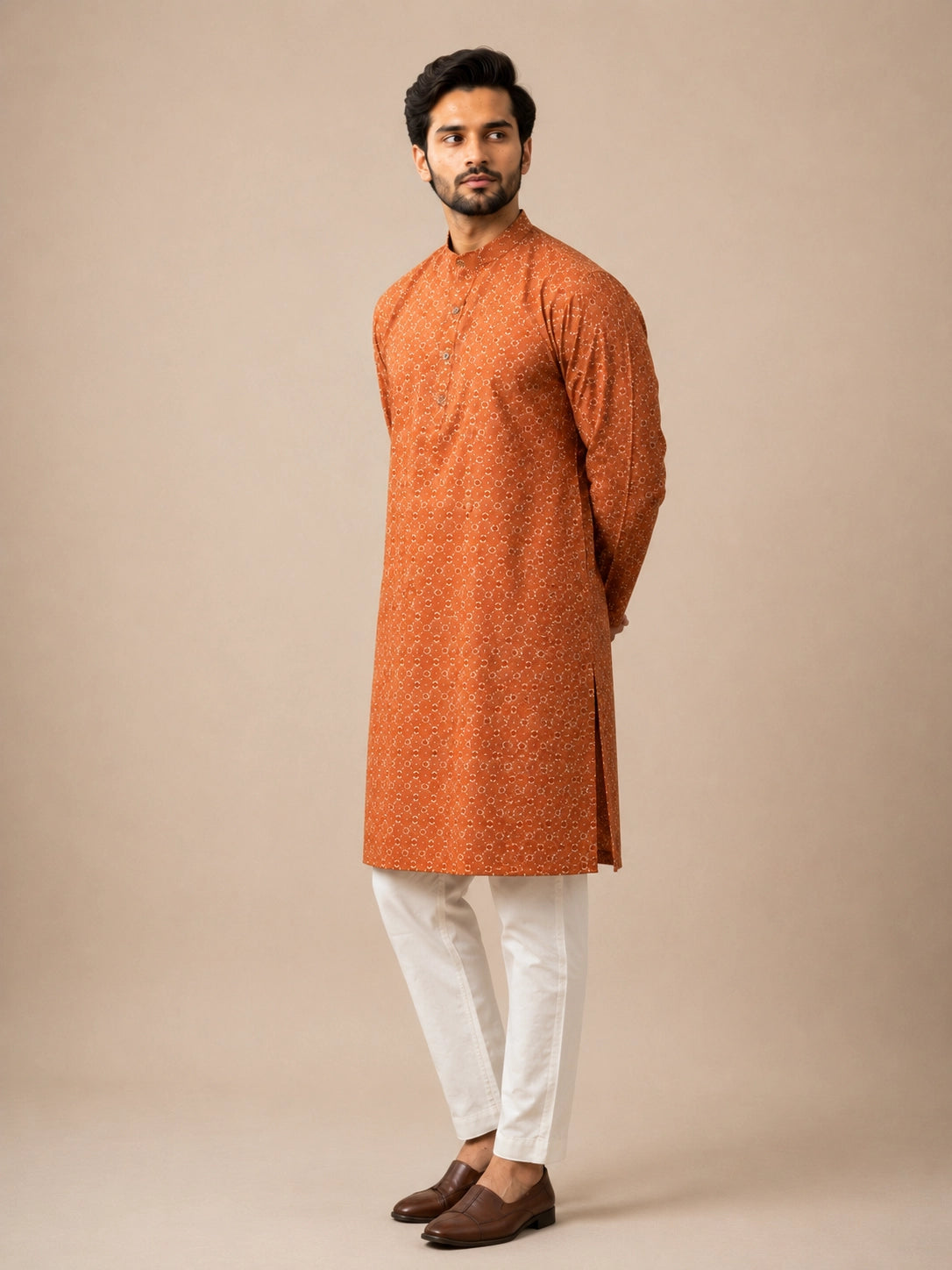 Man wearing a brown printed kurta with a band collar and white pajama.