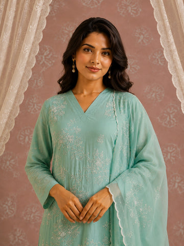 Woman wearing an elegant light green kurti with intricate white floral embroidery.