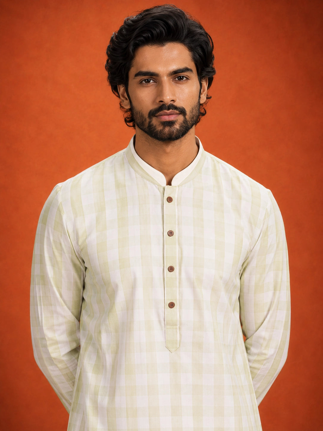 Full-length view of a man in a pista green checkered kurta and white pajama.