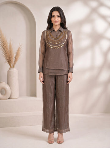 Woman wearing a grey sheer co-ord set with a detailed gold beaded and sequined neckline and wide-leg pants.
