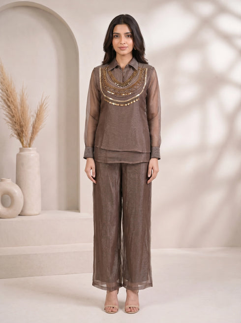 Woman wearing a grey sheer co-ord set with a detailed gold beaded and sequined neckline and wide-leg pants.