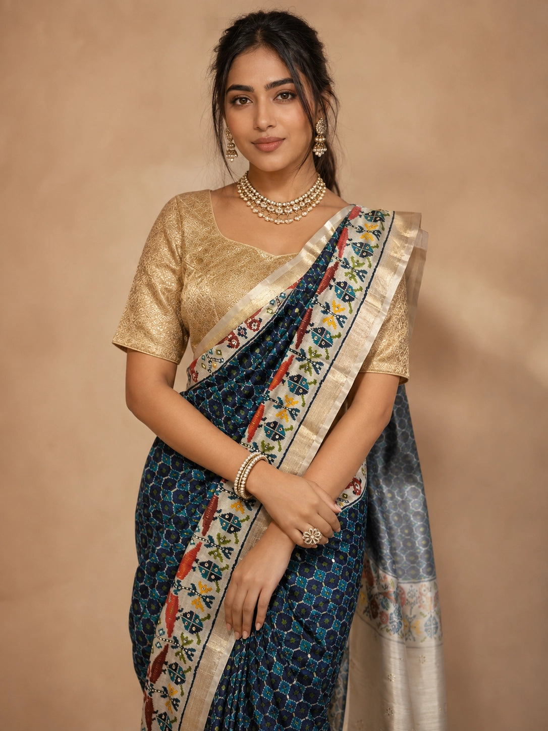 Woman in elegant navy blue  ikat saree with golden blouse and traditional jewelry.