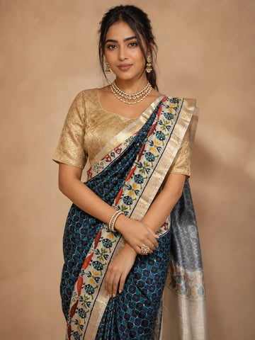 Woman in elegant navy blue  ikat saree with golden blouse and traditional jewelry.