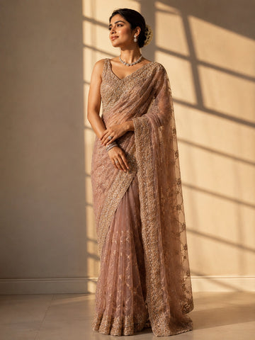 Woman in an elegant pink S3 embellished saree with intricate gold work and sleeveless blouse.