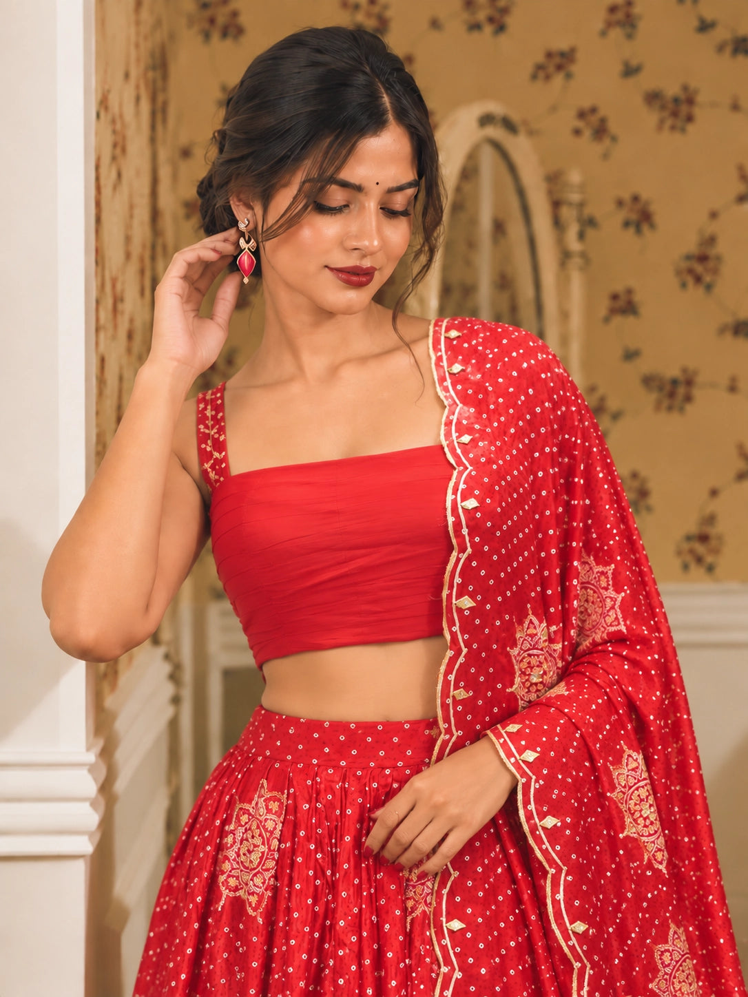 Vibrant red embroidered lehenga choli set with gold patterns and scalloped dupatta.