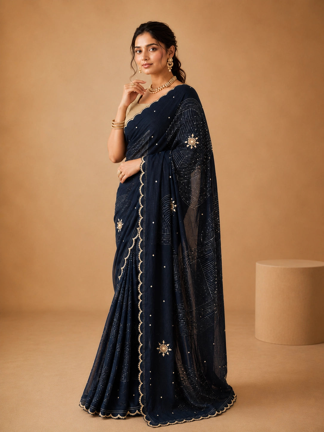 Woman wearing an elegant navy blue embroidered saree with a golden blouse and traditional jewelry.
