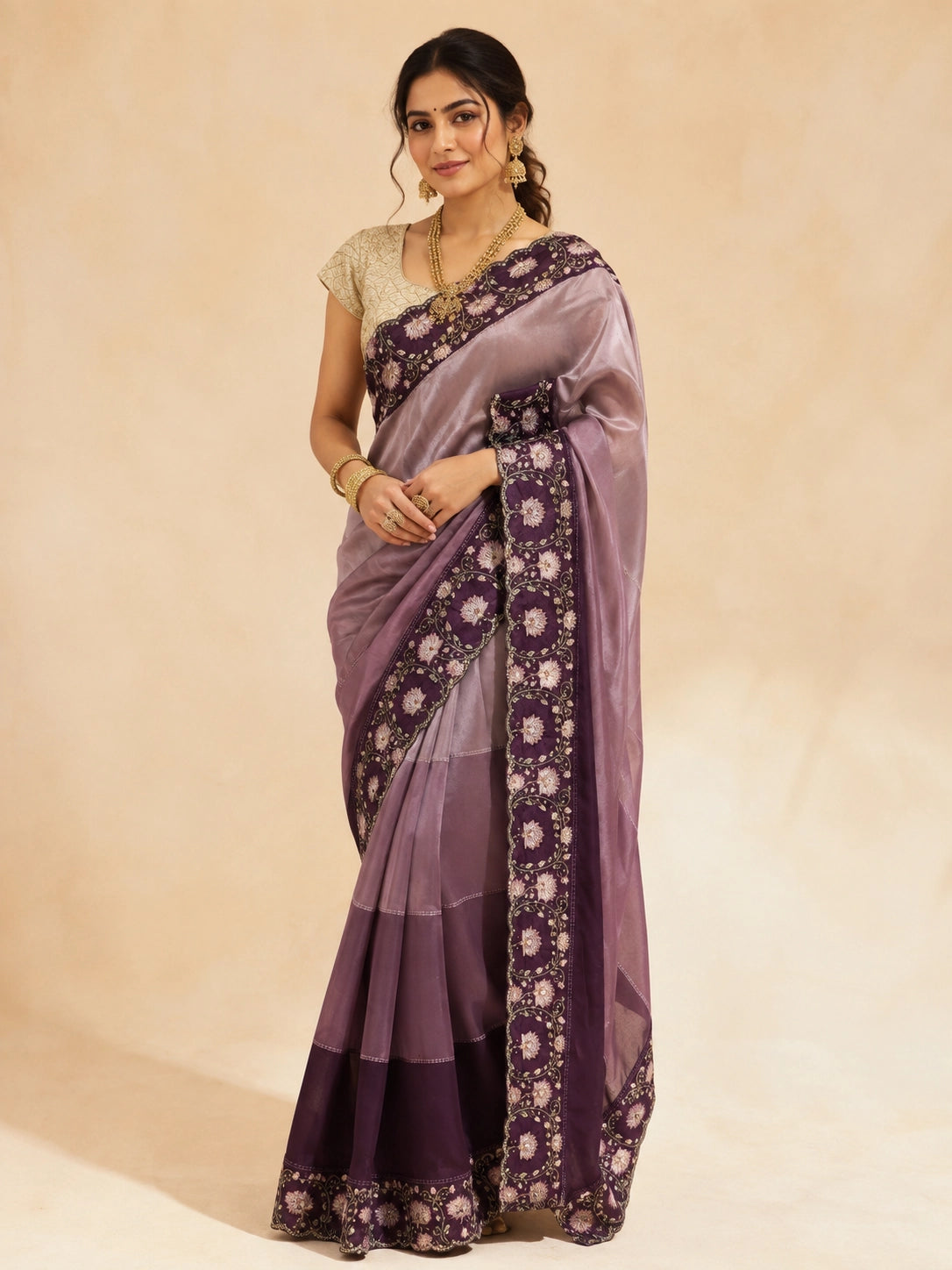 Woman in an elegant wine  saree with intricate floral embroidery and a golden blouse.