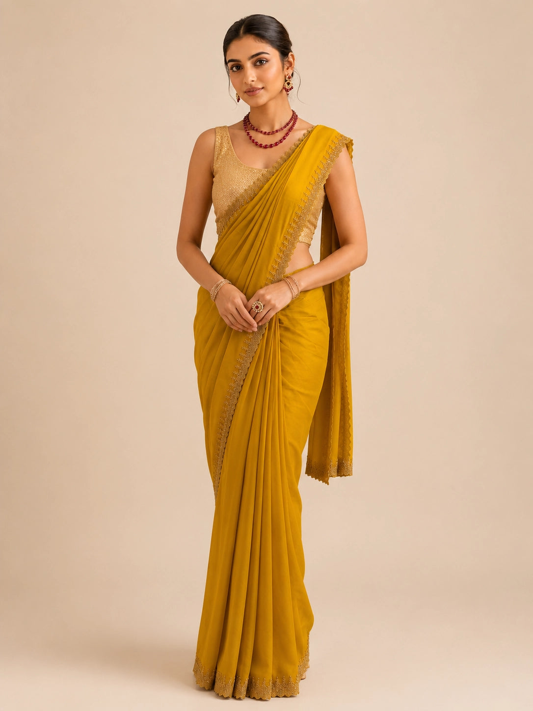 Woman in elegant mustard  saree with delicate embroidered border and golden blouse.