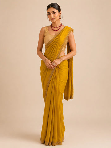 Woman in elegant mustard  saree with delicate embroidered border and golden blouse.