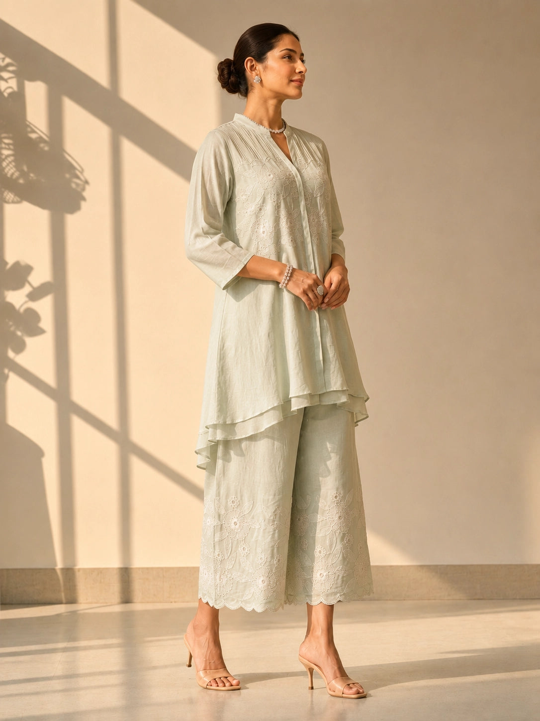 Woman in an elegant pista green embroidered tunic and wide-leg palazzo set.
