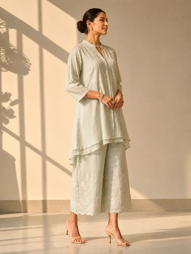 Woman in an elegant pista green embroidered tunic and wide-leg palazzo set.