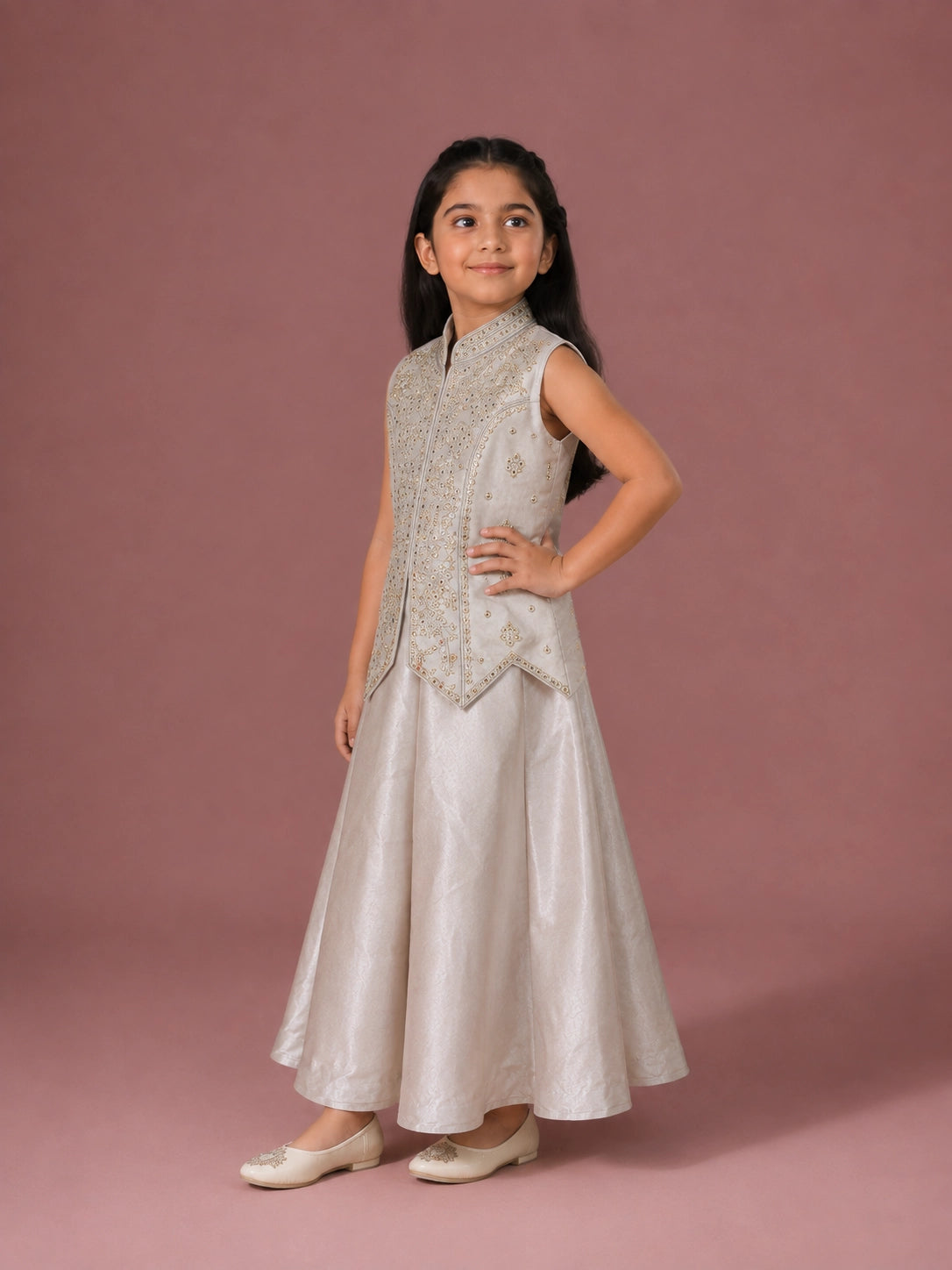 A young girl in a cream embroidered sleeveless top and matching wide-leg palazzo pants.