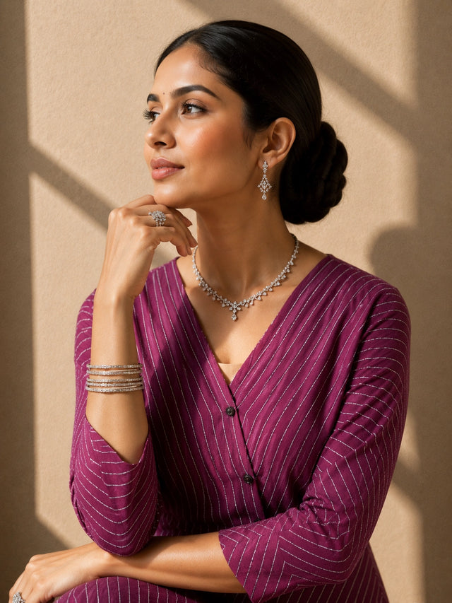 Woman wearing a purple striped V-neck top with layered hem and matching wide-leg pants.