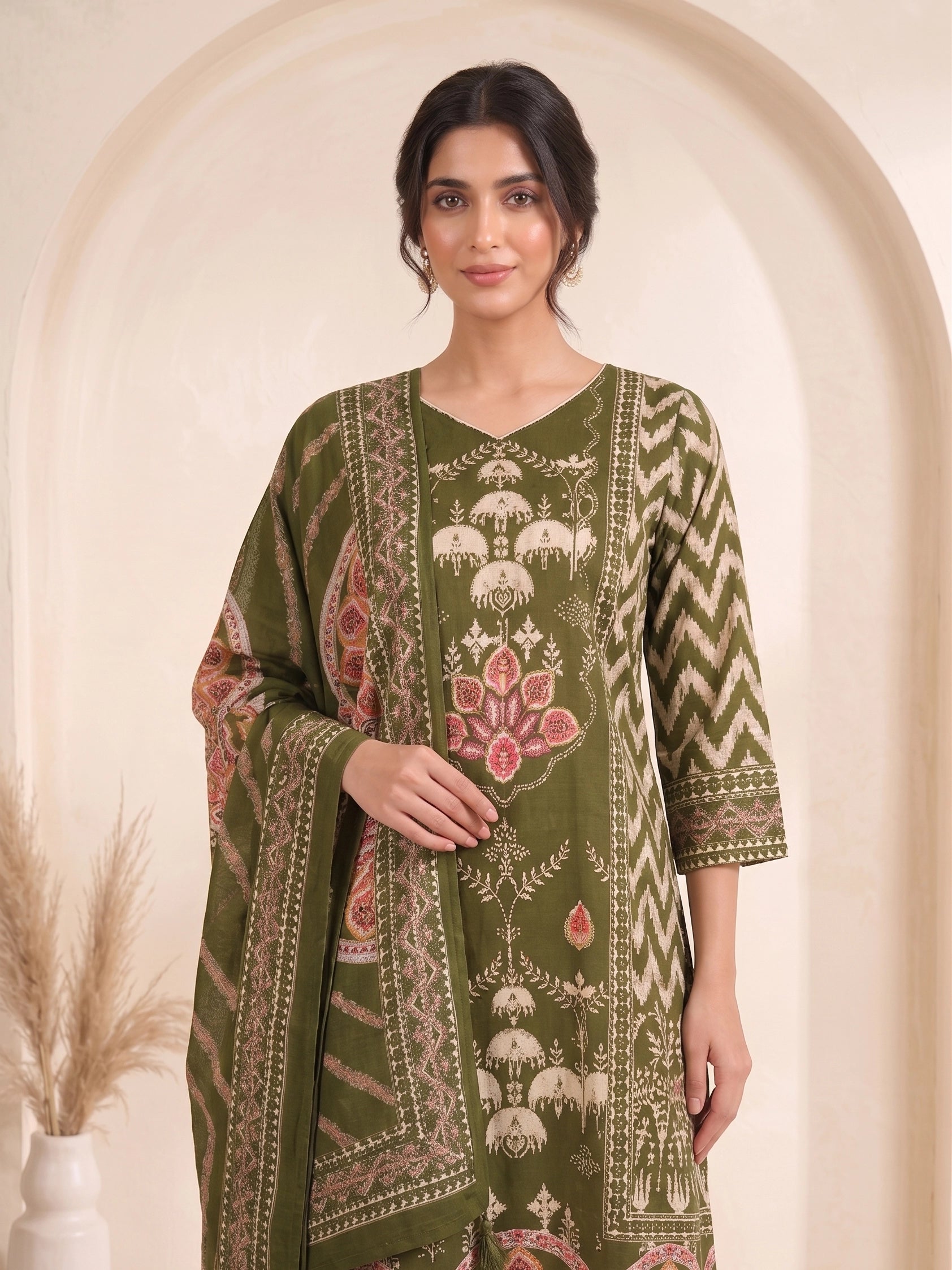 Woman wearing an olive green printed kurti set with palazzo pants and a matching dupatta.