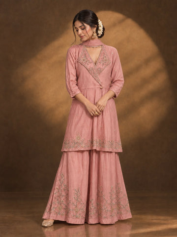 Woman in an elegant pink angrakha kurti and sharara set with intricate gold embroidery.