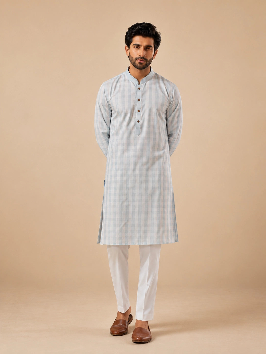 Man wearing a light sky blue and white checkered kurta with white pajamas.