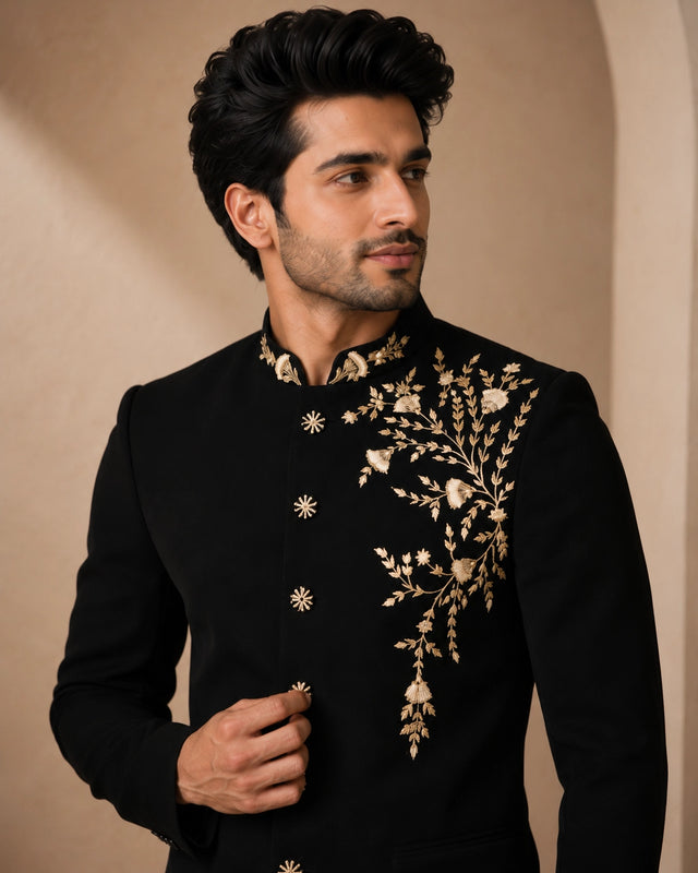 Man wearing a classic black Jodhpuri suit, a traditional Indian formal outfit.