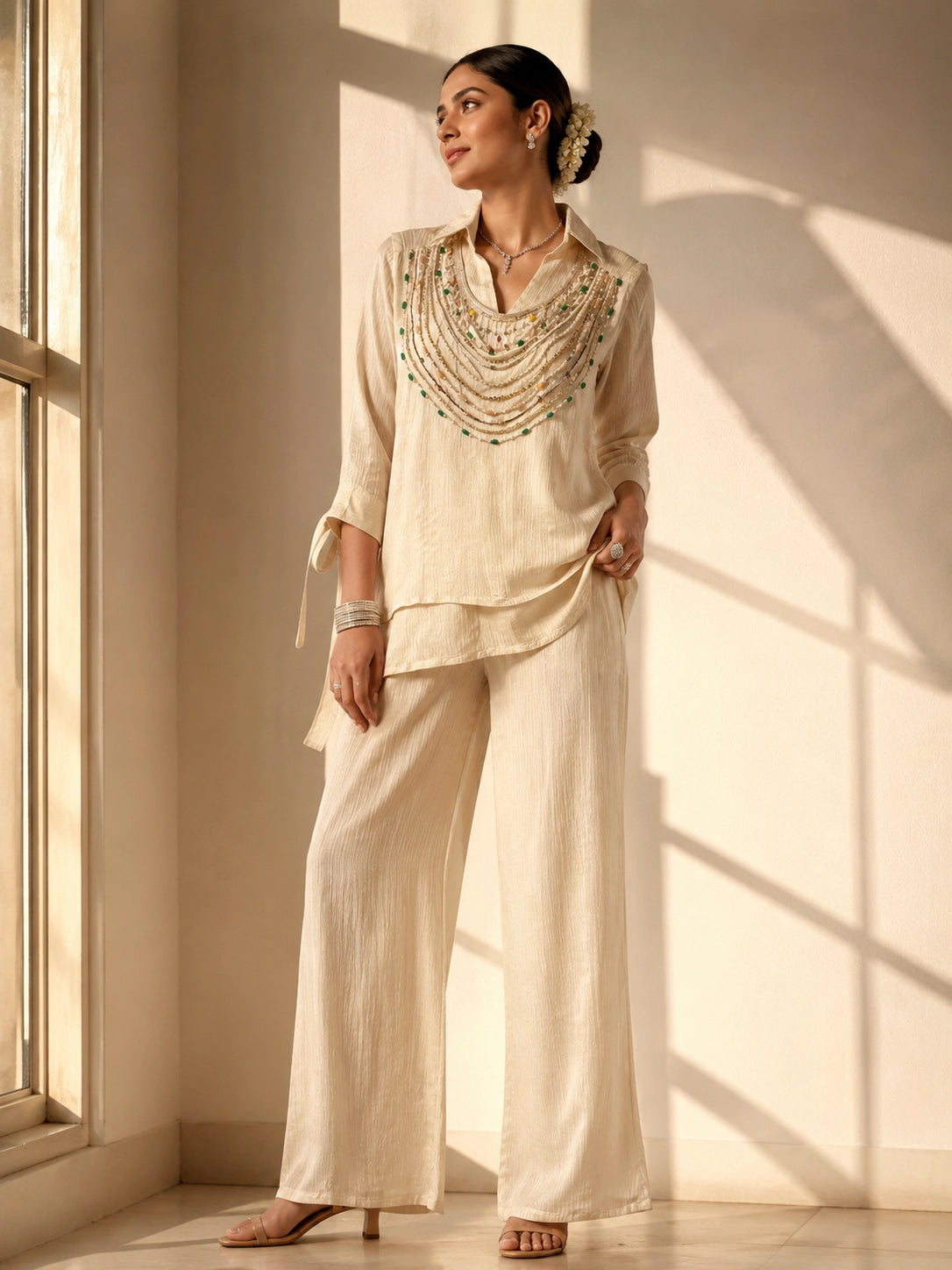 Woman wearing an elegant beige embroidered kurti with wide-leg palazzo pants.