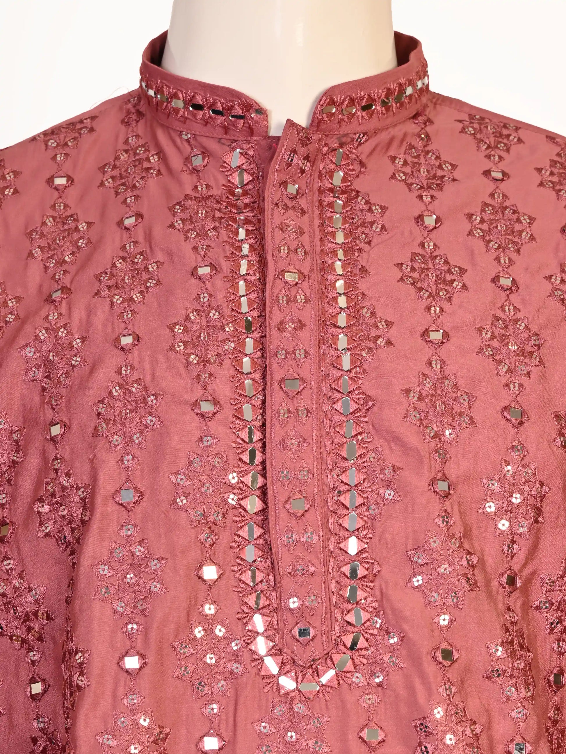 Man wearing a rose embroidered Kurta Pajama with white pants and brown jutti shoes.