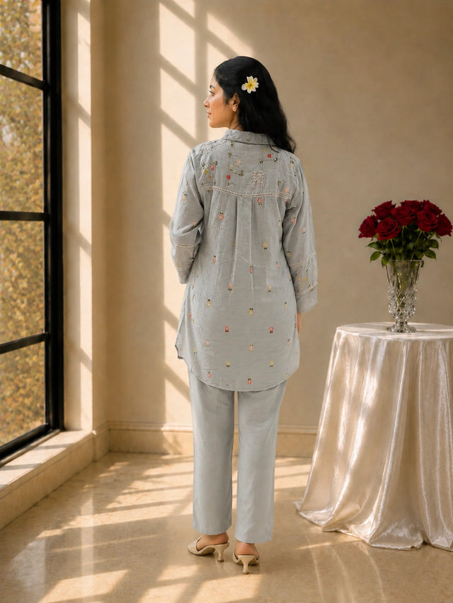 Woman in sky blue floral embroidered kurta set with matching pants.