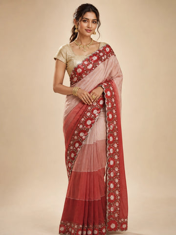 Woman in an elegant red ombre  saree with intricate white floral embroidery.
