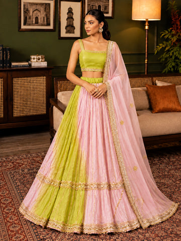 Elegant woman wearing a pink and green  lehenga choli with gold embroidery.