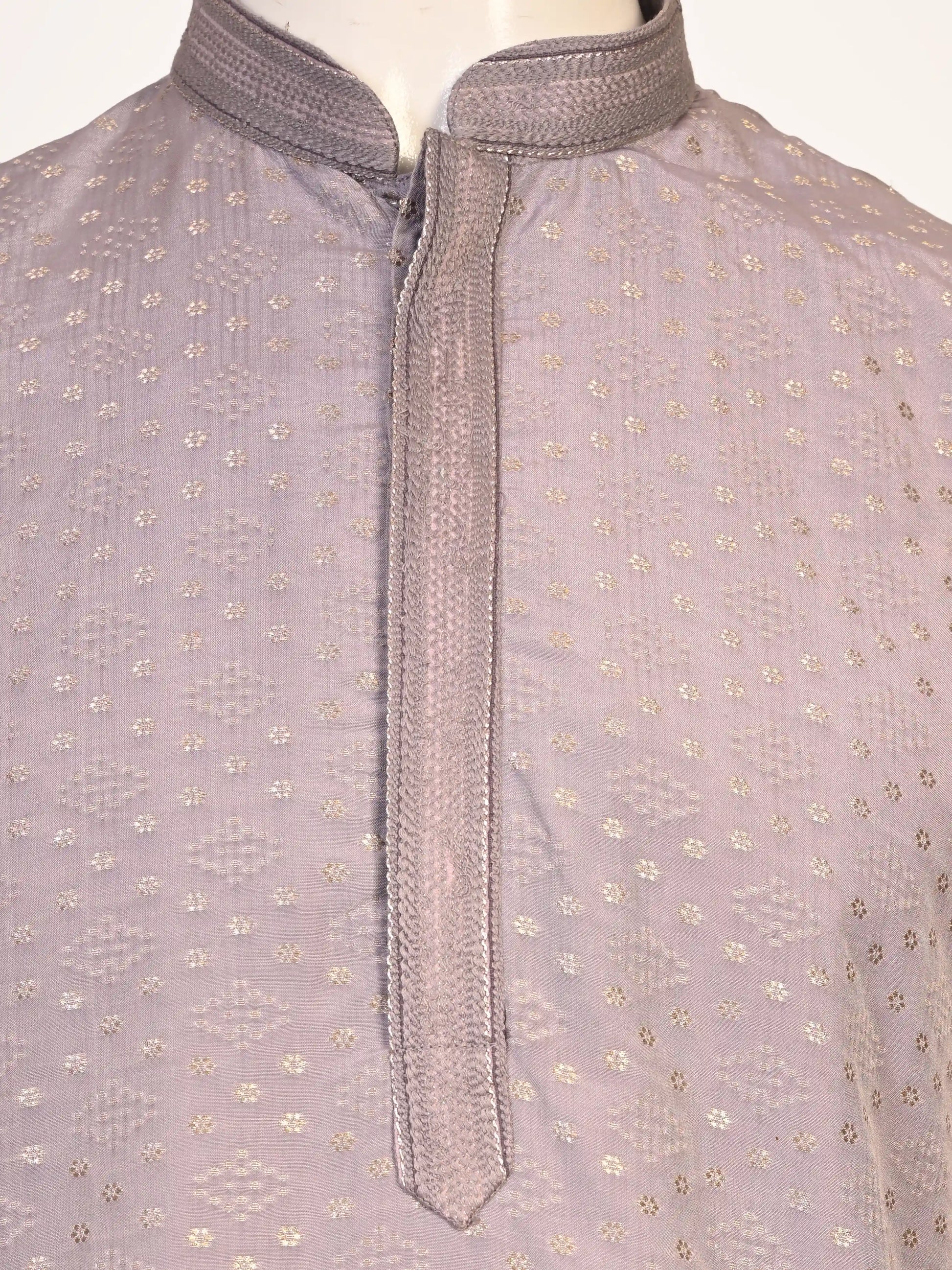 Man wearing a grey Kurta Pajama with a subtle geometric pattern and cream churidar pants.
