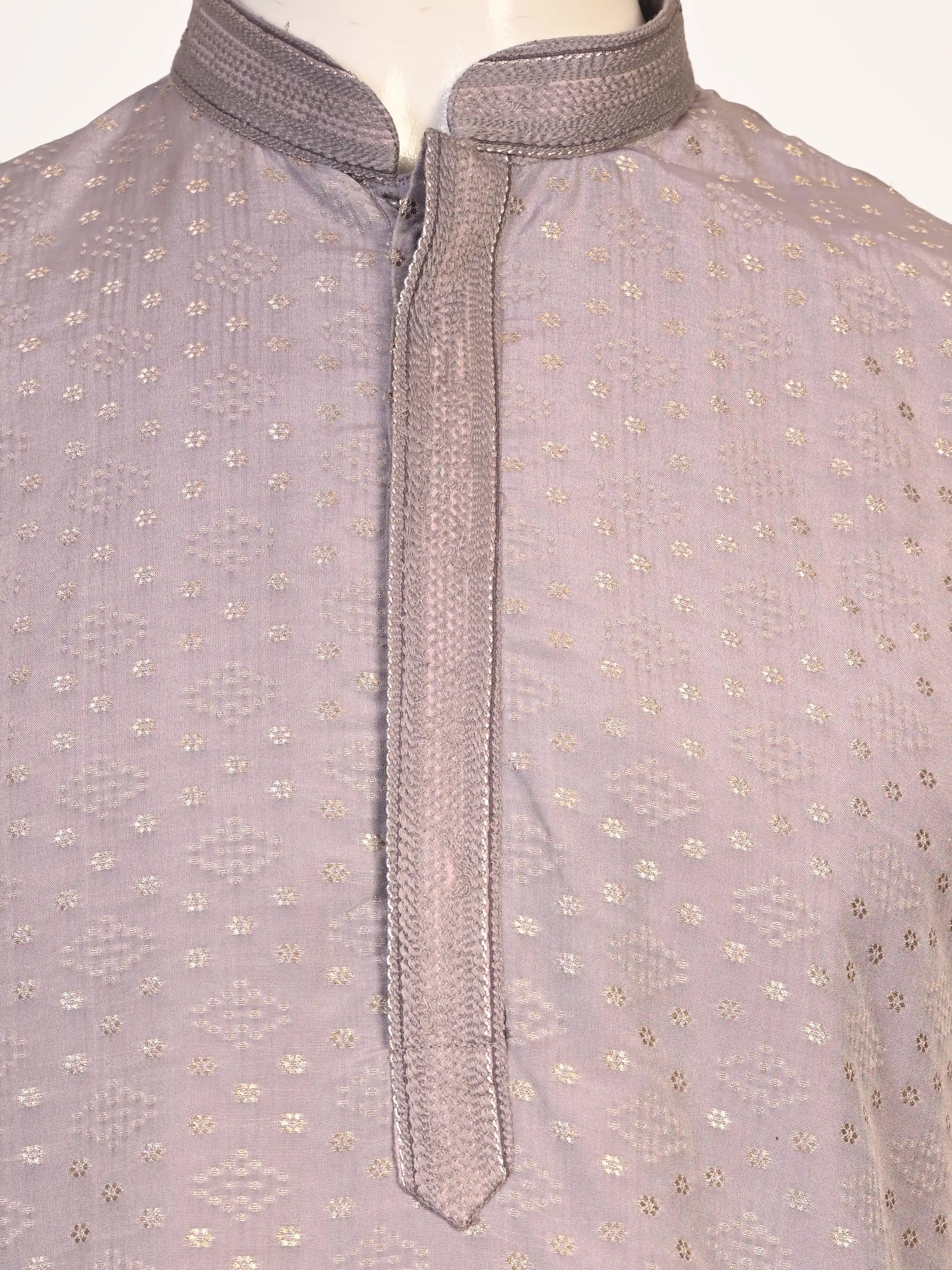 Man wearing a grey Kurta Pajama with a subtle geometric pattern and cream churidar pants.