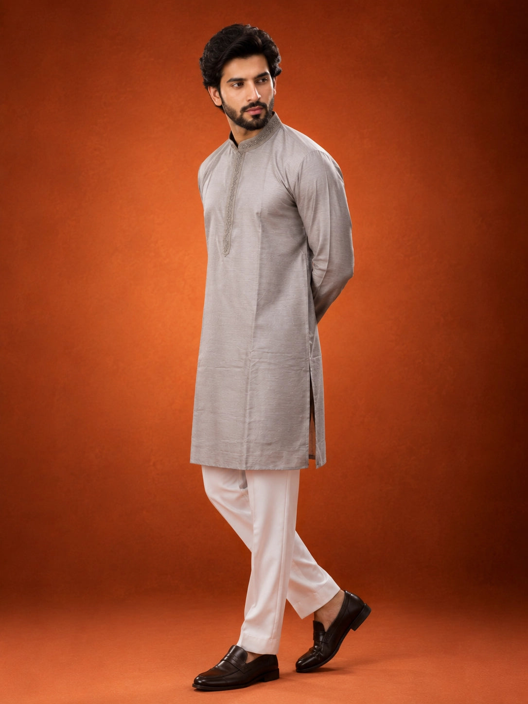 Man in elegant grey kurta with embroidered collar and white pajama set.