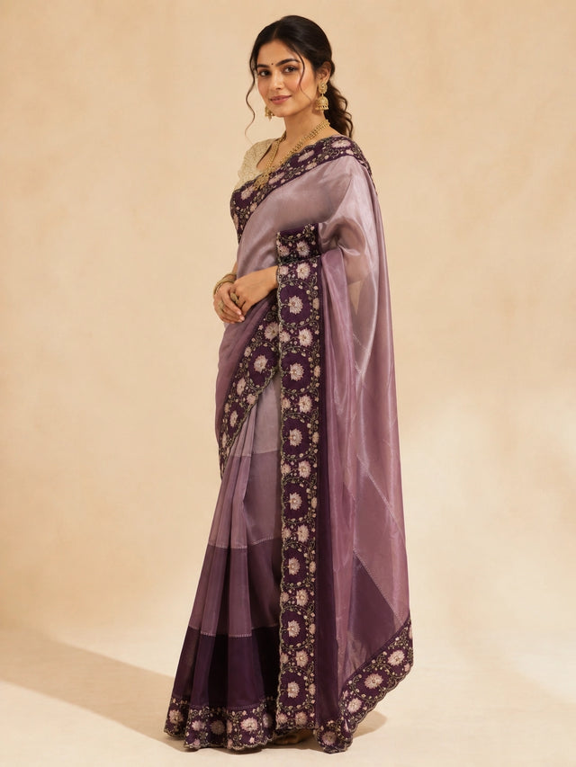 Woman in an elegant wine  saree with intricate floral embroidery and a golden blouse.