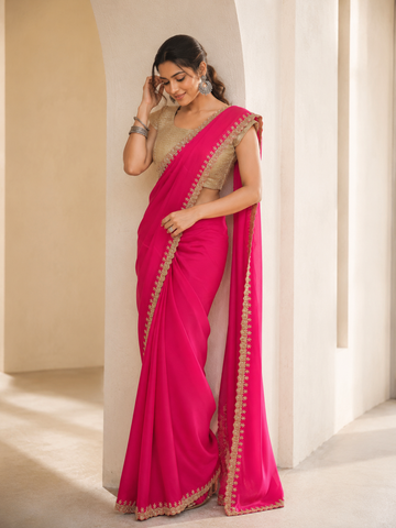 Woman wearing a vibrant rani pink saree with golden embroidered borders and a gold blouse.