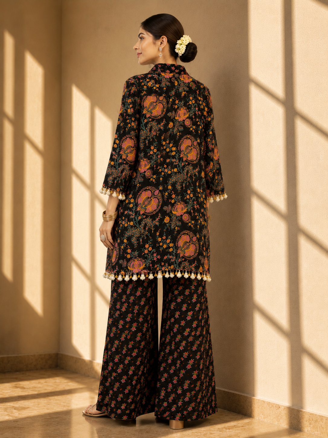 Woman in a black floral kurti set with embroidered V-neck and matching palazzo pants.